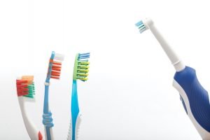 Three toothbrushes on white against the electric toothbrush